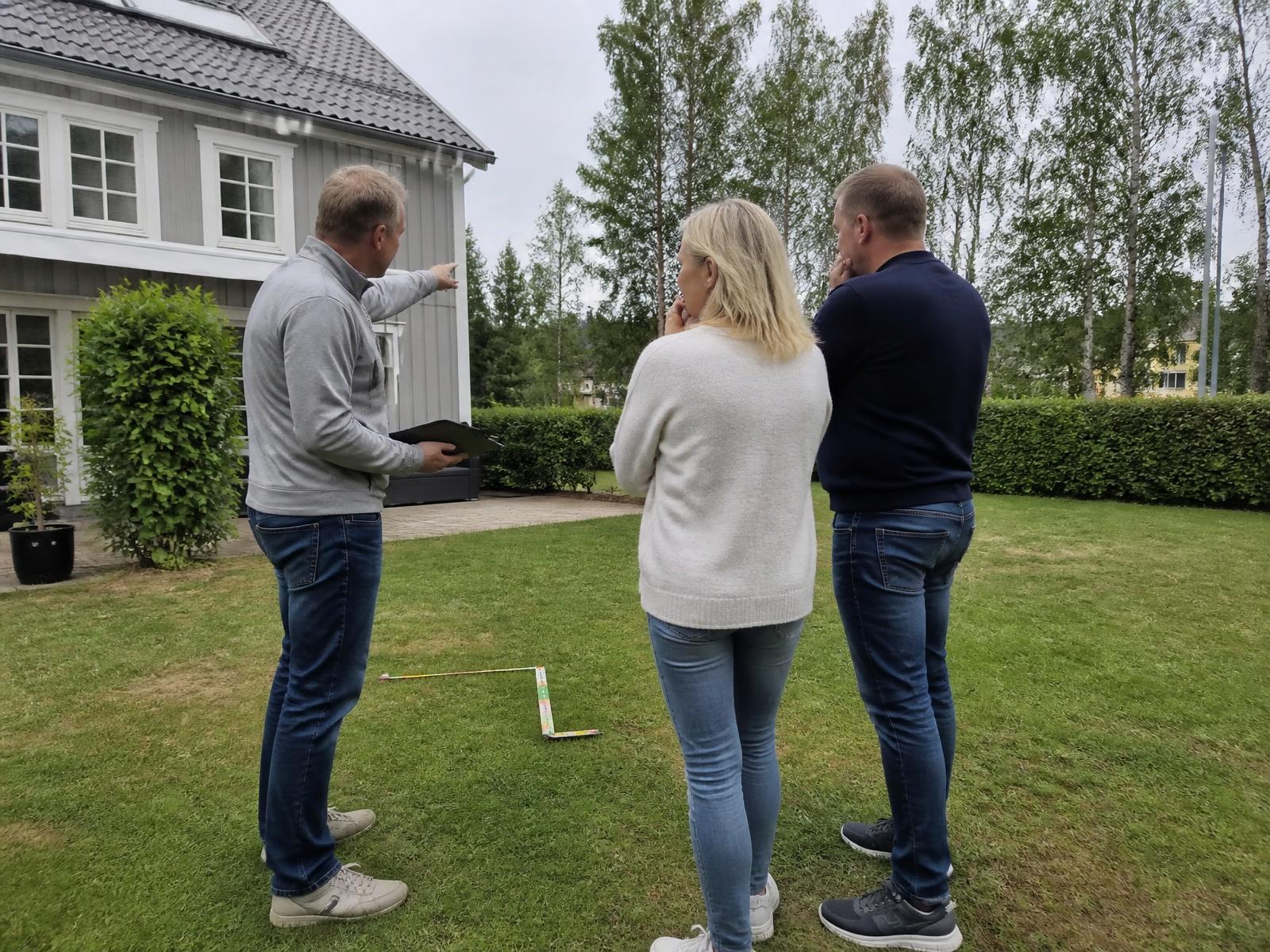 Barn som hoppar i poolen medan föräldrar sitter på trädäcket